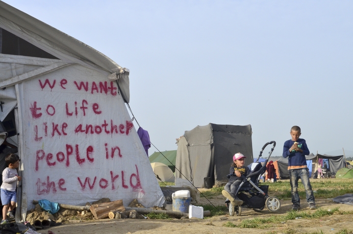 Niños en Idomeni con el mensaje 'We want to live like another people in the world'