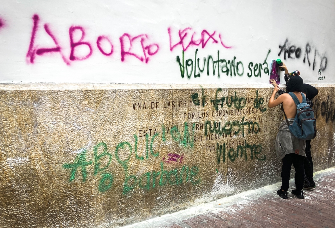 Manifestantes grafitean con stencil en la pared de una iglesia|Mujer del colectivo 'Bloque Feminista Radical' pinta "Aborto Legal" en la intersención de la 19 con séptima|Con pendones y afiches, las mujeres salieron a marchar en la tarde del 28 de septiembre|Con pintura en spray, muchas manifestantes intervinieron la ciudad|Cual aquelarre, las manifestantes se detuvieron frente al Consejo de Estado y arengaron por el aborto legal.|La manifestación concluyó con la quema de algunos versículos de la biblia, que ellas consideraron eran ofensivos contra la mujer.|||