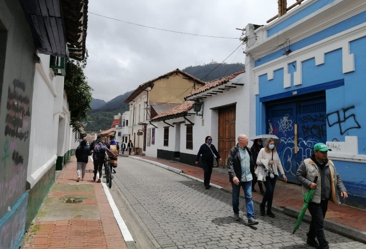 Turistas recorriendo el barrio La Candelaria en Bogotá en compañía de un guía. Foto de Paola Montañez