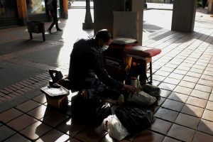 El sol mañanero abrazando la espalda del Señor Fernando|Un zapato a la vez|Sacando su carrito de un parqueadero cerca de su punto de trabajo|Leyendo el periódico mientras espera comensales|El señor Fernando comprando aromáticas a sus clientes|Jornadas laborales de aproximadamente 12 horas|Pasando por la plazoleta la estrella para llegar a su punto de trabajo|Con precisión y rapidez es el trabajo de un bolador|Además de lustrar zapatos, el Señor Fernando tiene un puesto de dulces|La virgen María que lo acompaña cada día|||