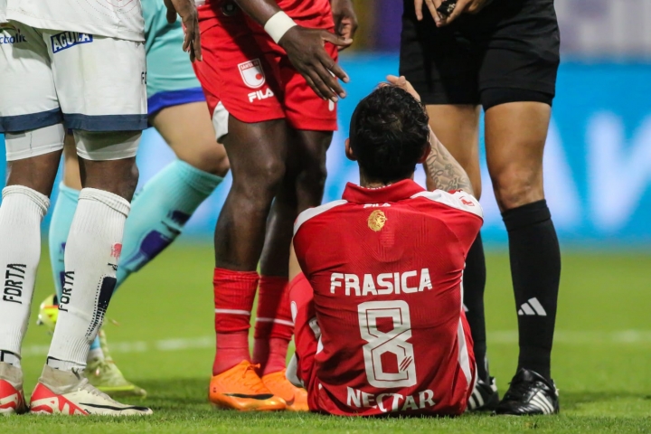 Omar Frasica recibiendo ayuda de sus compañeros de equipo