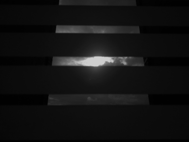 “El otro lado". El cielo se ve desde las ventanas de las casas, se vive desde una perspectiva muy oscura, sin poder salir. Se restringe el otro lado de la ventana.
